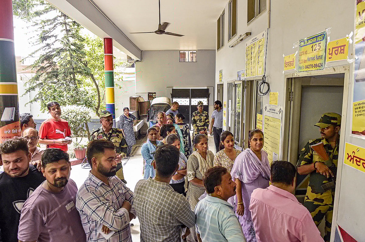 Voters stand in queues at a polling station to cast their votes during the Jalandhar West assembly bypoll, in Jalandhar, Wednesday - PTI